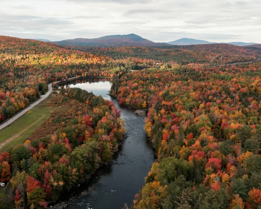 Aerial view of a river surrounded by colorful Vermont fall foliage
